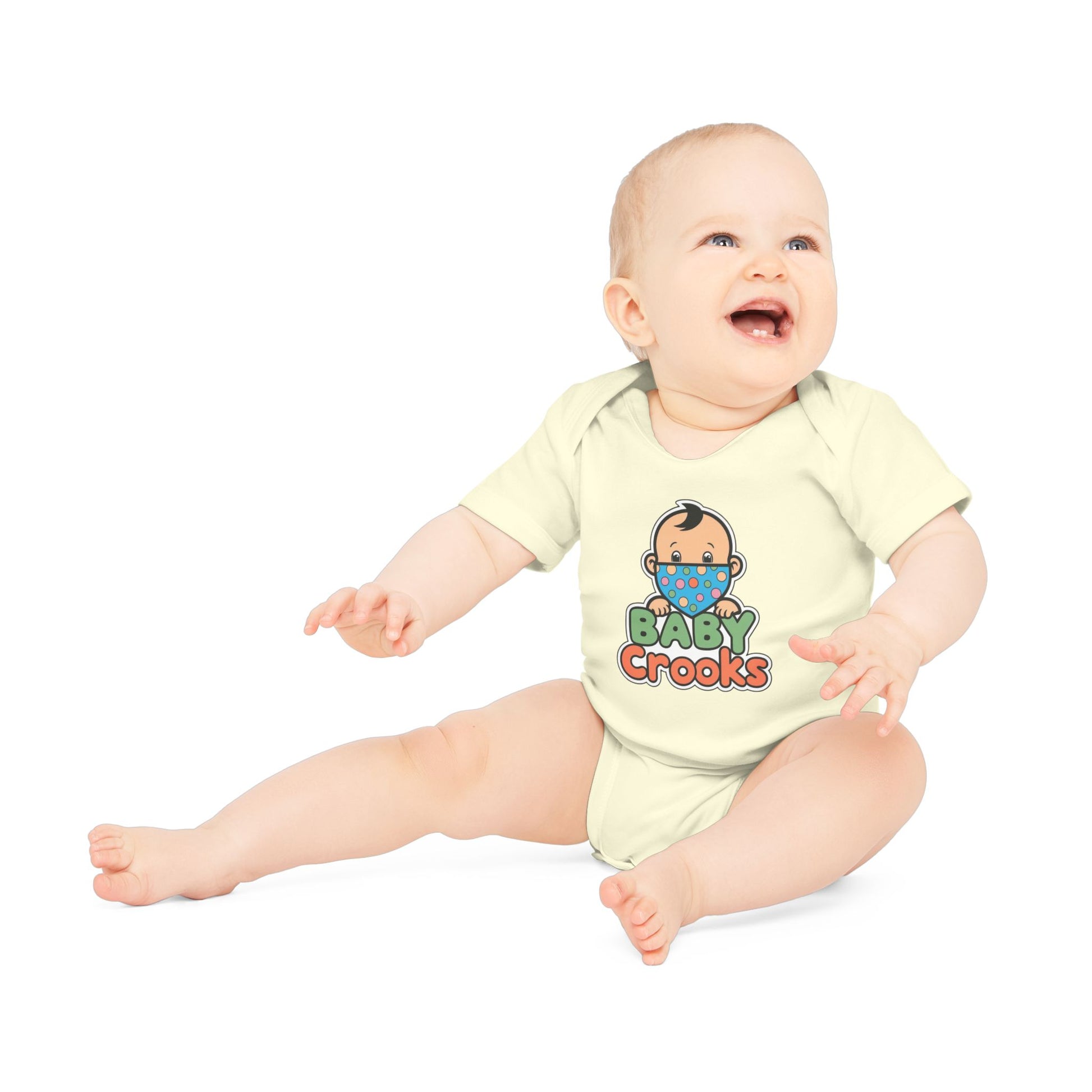 Baby wearing a yellow onesie with 'Baby Crooks' print on a white background